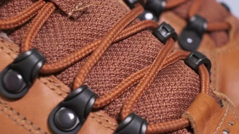 Closeup of rotating pair of fashionable wetherproof leather rufous boots Stock Footage 140488514