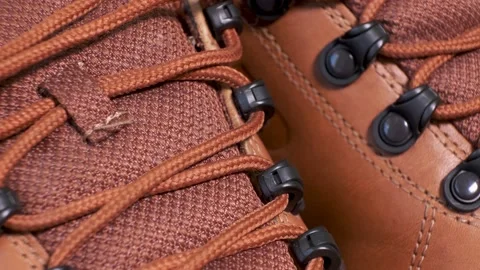 Closeup of rotating pair of fashionable wetherproof leather rufous boots Stock Footage 140562257