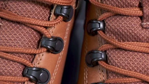 Closeup of rotating pair of fashionable wetherproof leather rufous boots Stock Footage 140704518