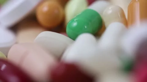 Closeup rotating pile of medication pills as seamless loop Stock Footage 156043073