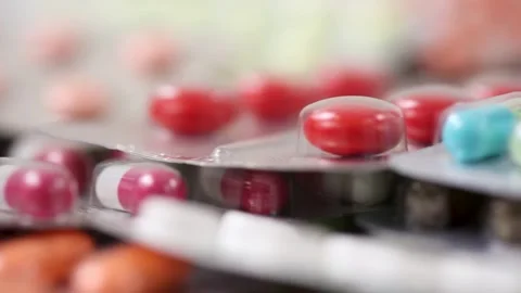 Closeup of rotating pile of pills in blisters with shallow depth of field Stock Footage 286218772