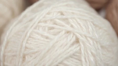 Closeup rotation of balls white and beige wool natural yarn. hobbies. macro. Stock Footage 252589655