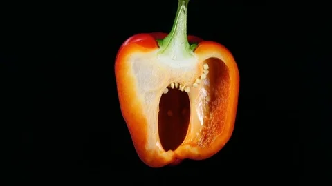 Closeup rotation of sliced red bell pepper on black background. 4K 動画素材 74059224
