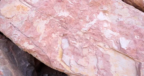 Closeup rough oval shaped pink rock with white mineral layers 4k Stock Footage 316551027