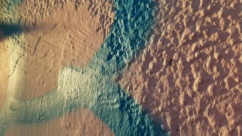 Closeup of rough stone wall surface painted in pink and blue colors Foto stock