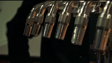 Closeup on a row of beer taps in a bar - a customer pays to the bartender in the Stock Footage 82681143
