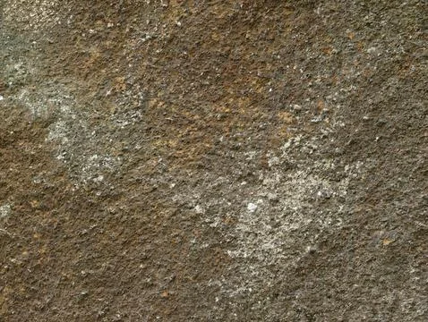 Closeup rugged rock texture with brown gray mottling, rust specks, and lich.. Stock Photos