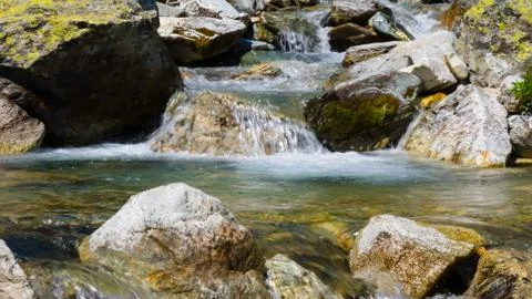 Closeup rushing mountain river with small waterfall Stock Photos