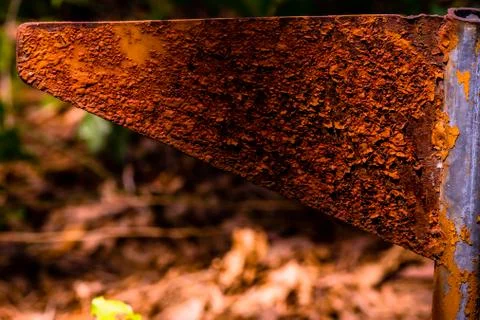 Closeup of rusted triangular metal flag pole in forest with blurred backgroun Stock Photos