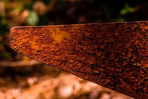 Closeup of rusted triangular metal flag pole in forest with blurred backgroun Stock Photos