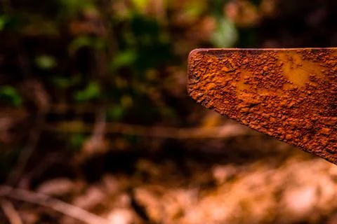 Closeup of rusted triangular metal flag pole in forest with blurred backgroun Stock Photos