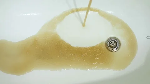Closeup of rusty water running from the tap in a bath. Hazardous tap water flows Stock Footage 210448144