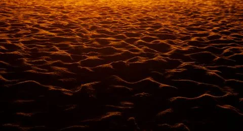 Closeup of sand pattern of a beach in the sunset. Stock Photos