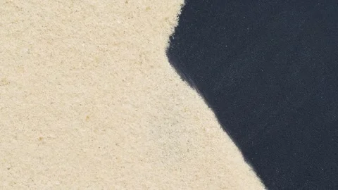 Closeup of sand transition blowing over black abstract background in slow motion Stock Footage 253845523