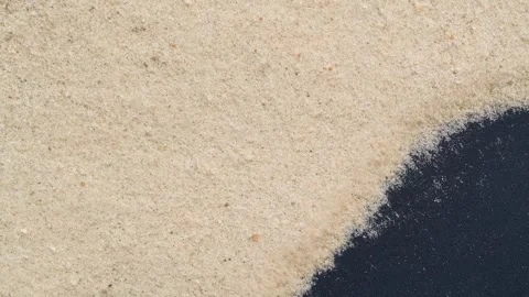 Closeup of sand transition blowing over black abstract background in slow motion Stock Footage 320856056