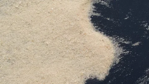 Closeup of sand transition blowing over black abstract background in slow motion Stock Footage 321669823