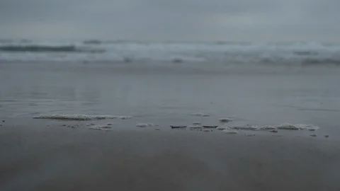 Closeup of sandy beach with waves in background Stock Footage 125802997