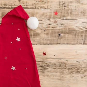 Closeup of Santa's red hat on old natural wooden background with shinny silve Stock Photos