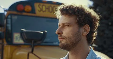Closeup schoolbus chauffer face at vehicle. Handsome man driver looking camera. Foto stock