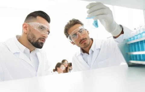 Closeup. scientist and assistant studying the solution in the glass tube Stock Photos