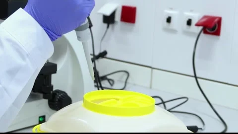 Closeup scientist discarding micropipette tip in biohazard container Stock Footage 296884315