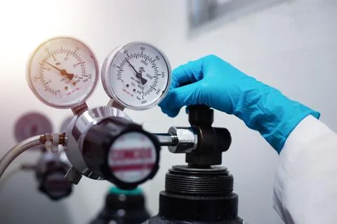 Closeup of a scientist's hand, checking gas from pressure gauge for a labor.. Stock-Fotos