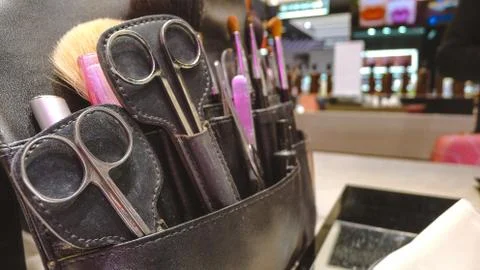 Closeup of scissors combs and make tool in a salon holster pouch .sets of mak Foto stock
