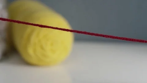 Closeup of scissors cutting a red string of yarn Stock Footage 82809444
