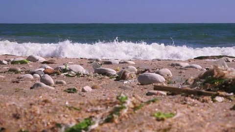 Closeup of sea pebbles against the backdrop of a stormy sea Stock Footage 90674293