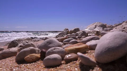 Closeup of sea pebbles against the backdrop of a stormy sea Stock Footage 90678443