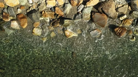 Closeup of sea waves flowing around the rocks on the shore. slow motion Stock Footage 224401278
