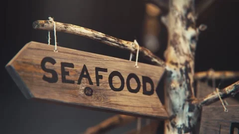 Closeup of Seafood wooden sign, dust in air Stock Footage