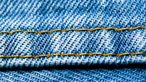 Closeup light blue jeans denim fabric texture background. Stock