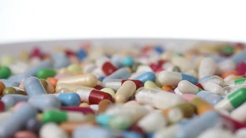 Closeup seamless loop of a clockwise rotating plate with pills Stock Footage 288107260