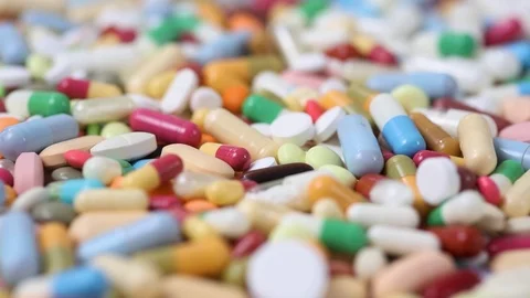 Closeup seamless loop shot of pile of colorful pills rotating Stock Footage 123479244