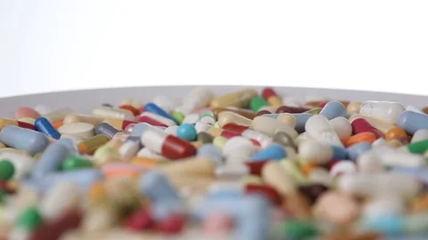 Closeup seamless loop shot of a rotating plate with many pills Stock Footage 123479248