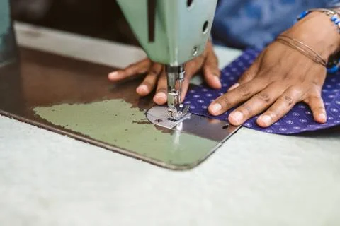 Closeup of a seamstress stitching textiles using her sewing machine Stock Photos