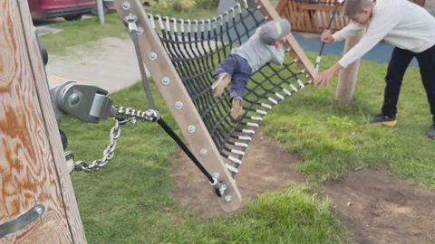 Closeup of secure hammock chain supporting child swinging outdoors Stock Footage 330324323