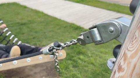 Closeup of secure hammock chain supporting child swinging outdoors Stock Footage 330324332