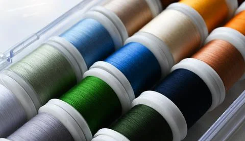 Closeup of selection of colorful threads for sewing machine. Tailoring tools. Stock Photos