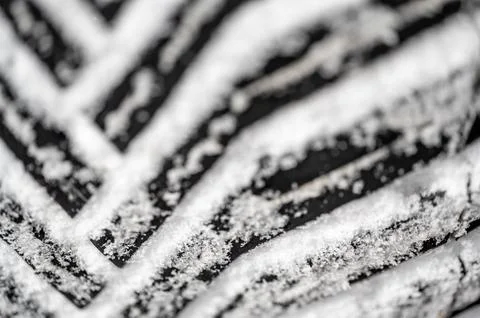 Closeup selective focus on snow packed in an all-weather tire tread. Stock Photos