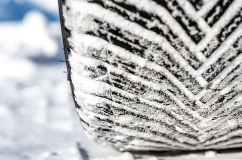 Closeup selective focus on snow packed in an all-weather tire tread. Stock Photos