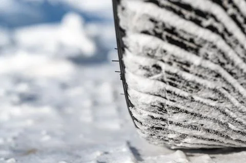 Closeup selective focus on snow packed in an all-weather tire tread. Stock Photos