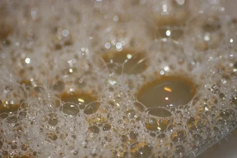 Closeup selective view of Foam and soap bubbles over water. Stock Photos