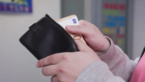 Closeup sequence of hands handling euro banknotes from wallet in office setting Stock Footage 309585720