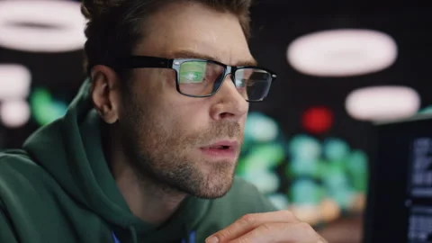 Closeup serious developer working at night datacenter. Tired man found mistake Stock Footage 260253147