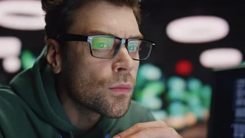 Closeup serious developer working at night datacenter. Tired man found mistake Stockfoto's