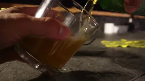 Closeup serving beer from a can. in a glass cup with hands on the roof at night Stock Footage 186229873