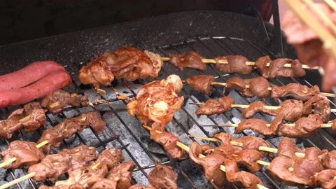 Closeup of several anticuchos sticks on a grill cooking with charcoal Stock Footage 143373053