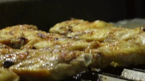 Closeup of several chicken wings and legs cooking on the grill at night Stock Footage 194502242